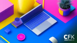 Uma mesa colorida com um laptop, uma planta, uma caneca e vários objetos geométricos em uma superfície rosa e azul vibrantes.