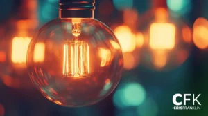 Close de uma lâmpada de estilo vintage iluminada com um filamento visível, cercada por um fundo quente e desfocado de luzes semelhantes.