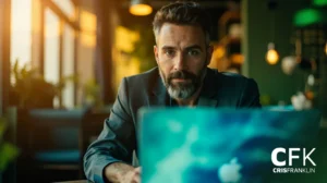 Um homem de barba e terno está sentado à mesa trabalhando em um laptop em um café moderno com pouca iluminação; o logotipo "CFK CRIS FRANKLIN" é visível no canto inferior direito.
