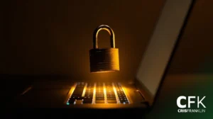 Um cadeado paira sobre um teclado de laptop, iluminado por uma luz quente, simbolizando a segurança cibernética. O logotipo "CFK CRISFRANKLIN" aparece no canto inferior direito.