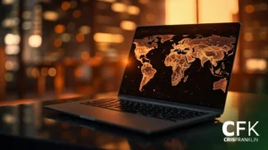 Um laptop exibindo um mapa-múndi digital com continentes iluminados está sobre uma mesa em uma sala pouco iluminada. As iniciais "CFK" estão visíveis no canto inferior direito.