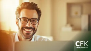 Um homem de cabelos escuros e óculos sorri para um laptop em uma sala bem iluminada. O logotipo da CFK Cris Franklin aparece no canto inferior direito.
